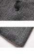 Close-up of gray glen plaid blazer button and fabric texture. Black button positioned on intersecting pattern lines shows quality craftsmanship