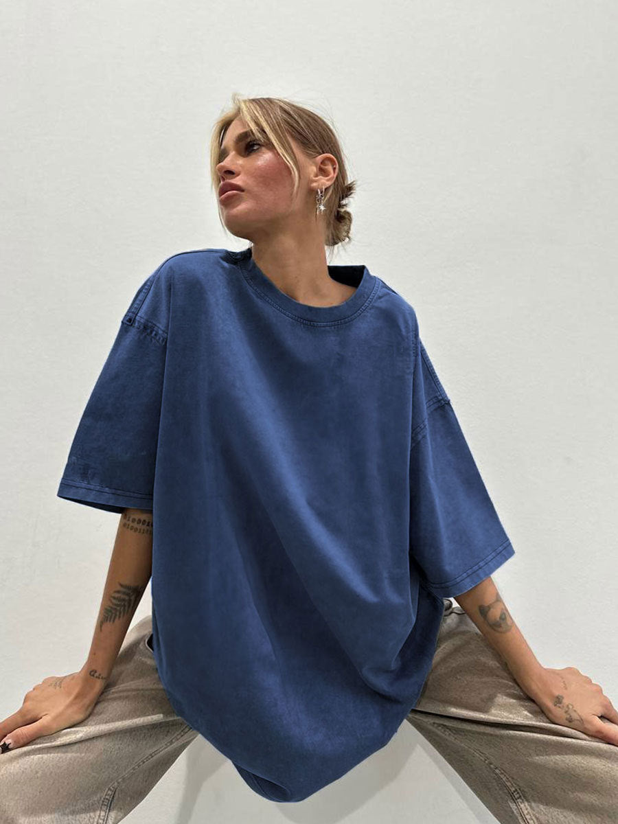 Person wearing a blue oversized t-shirt against a plain background