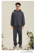 Man wearing charcoal gray hoodie and matching sweatpants with white sunglasses against floral background