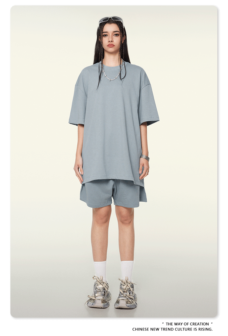 Woman seen from behind wearing light blue oversized T-shirt and matching shorts with white socks and sneakers