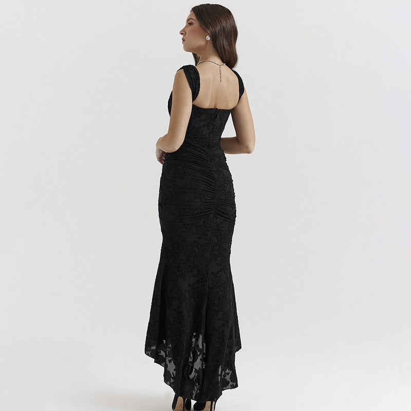 A model is posing with back towards camera wearing a black lace formal dress with ruched detail and high-low hemline against white background
