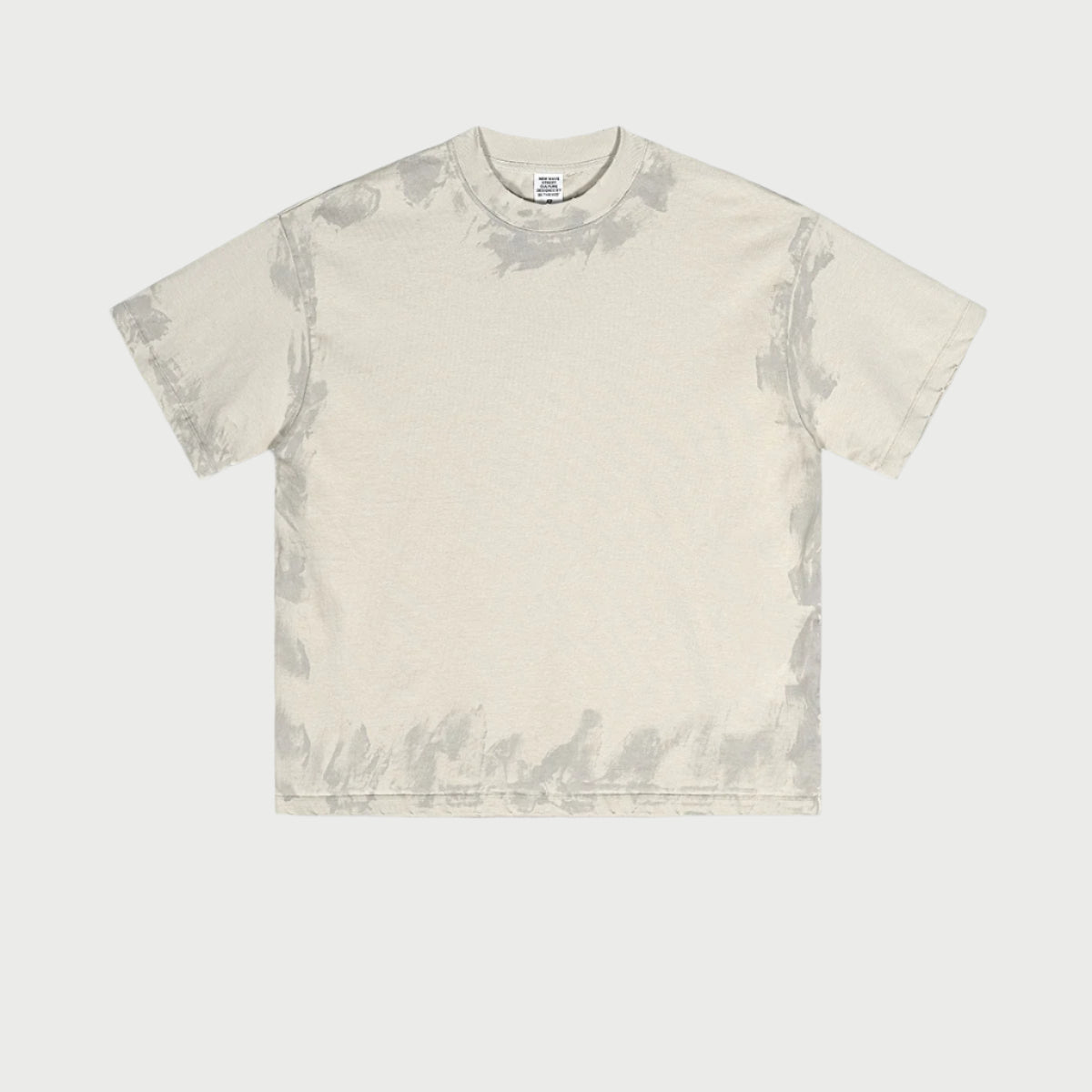 Light beige oversized t-shirt displayed flat showing subtle wash effect and brand tag. Features boxy silhouette and crew neckline