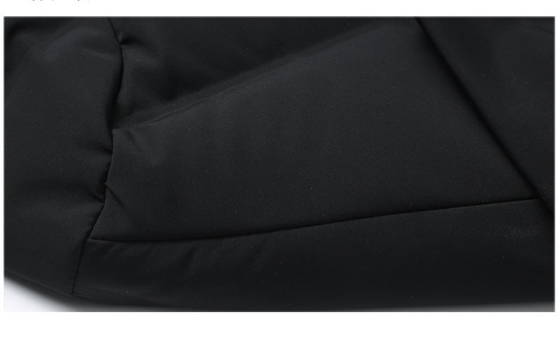 Detail of side pocket on black quilted coat showing clean tailored construction