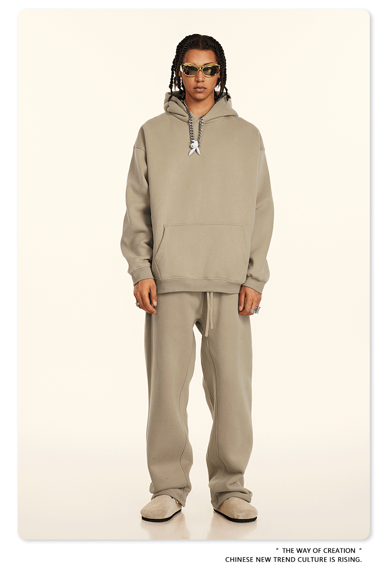 Model wearing beige hoodie and sweatpants with yellow-tinted sunglasses and coordinating footwear