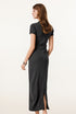 The back view of a woman wearing a dark grey short-sleeved maxi dress, styled with a delicate watch.