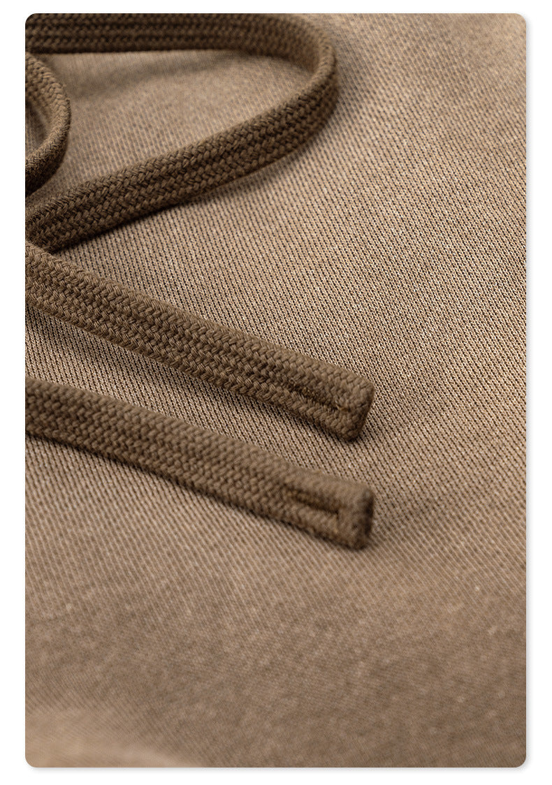 Detail of brown braided drawstring cord texture on taupe sweatpants fabric