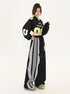 Side angle of model in black cropped athletic jersey, oversized wide-leg pants with contrast white lace trim and triple stripe detail, yellow and gray sneakers