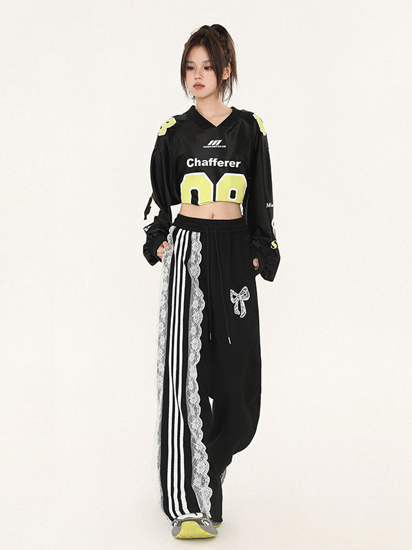 Front view of model in modified sports jersey crop top with 'Chafferer' logo, black wide-leg pants with decorative white lace panel, yellow-accented sneaker