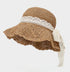 A khaki straw sun hat with a wavy brim, featuring a delicate white lace ribbon tied into a bow, perfect for summer elegance.