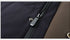 Close-up of a black puffer coat’s zipper and button details, featuring a contrast brown lining and sturdy metal fasteners