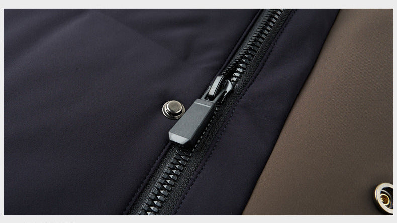Close-up of a black puffer coat’s zipper and button details, featuring a contrast brown lining and sturdy metal fasteners