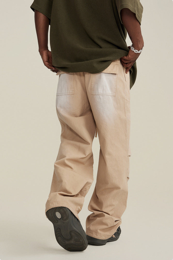 Back view of model with hands in pockets wearing olive shirt and beige utility pants