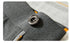 Close-up of metal button detail on gray dress pants fabric