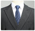 Close-up of suit lapel and navy striped tie, highlighting wool fabric texture and pattern details