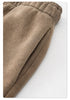 Close-up of taupe sweatpants fabric showing texture and elastic gathering detail