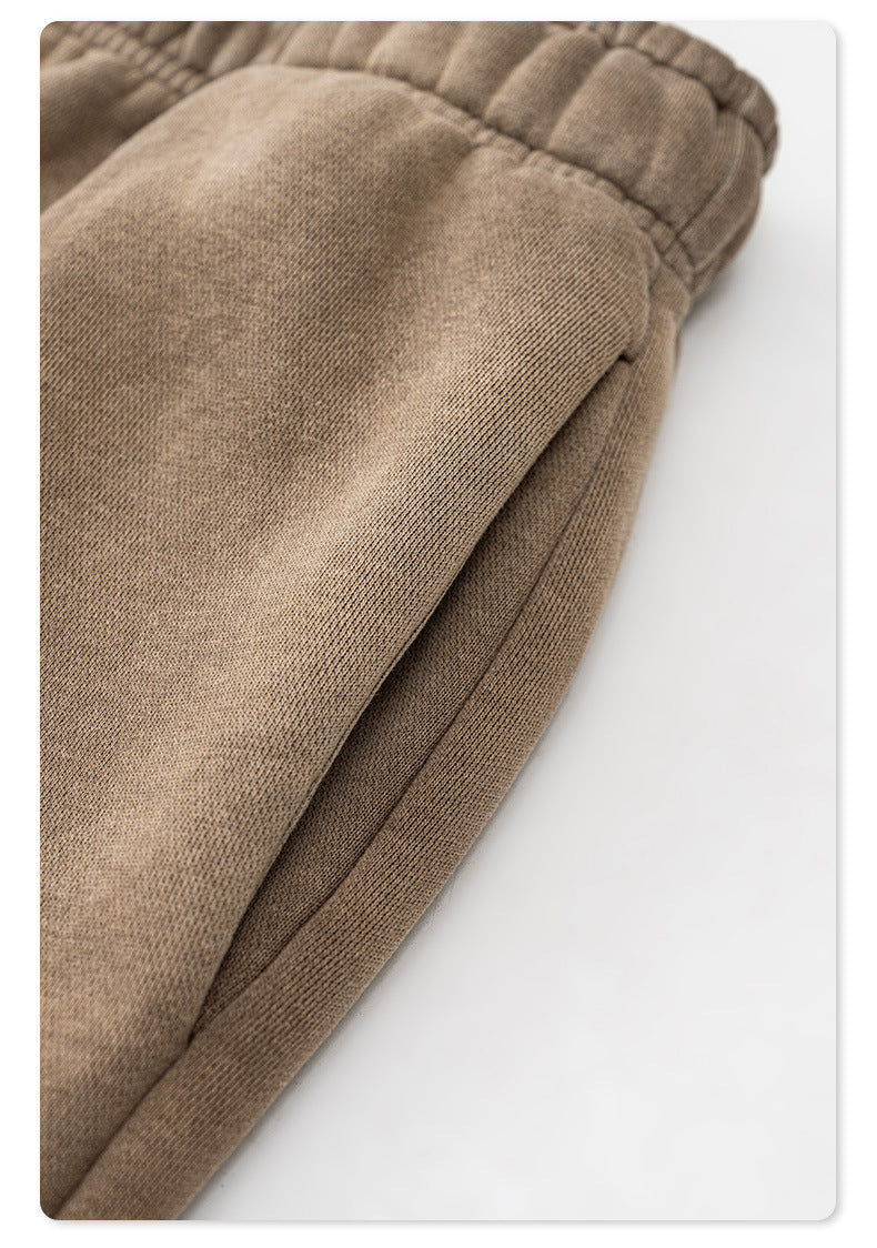 Close-up of taupe sweatpants fabric showing texture and elastic gathering detail
