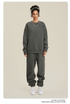 Model in dark gray sweatsuit with white headband, silver necklace and white sneakers