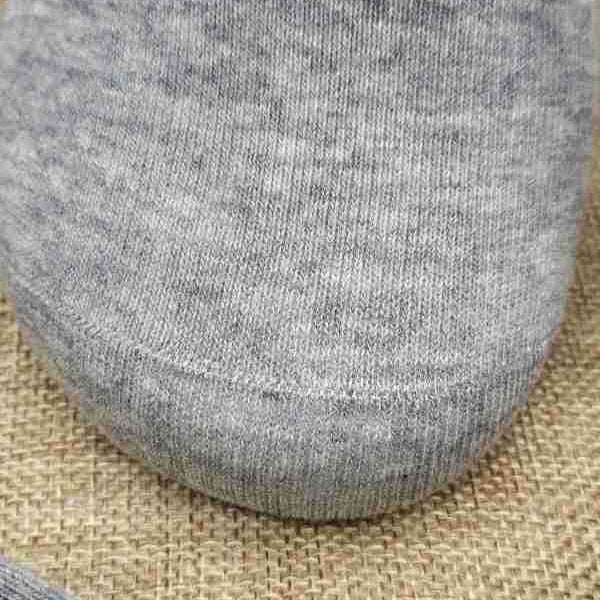Close-up texture of heather gray cotton blend sock fabric on burlap background