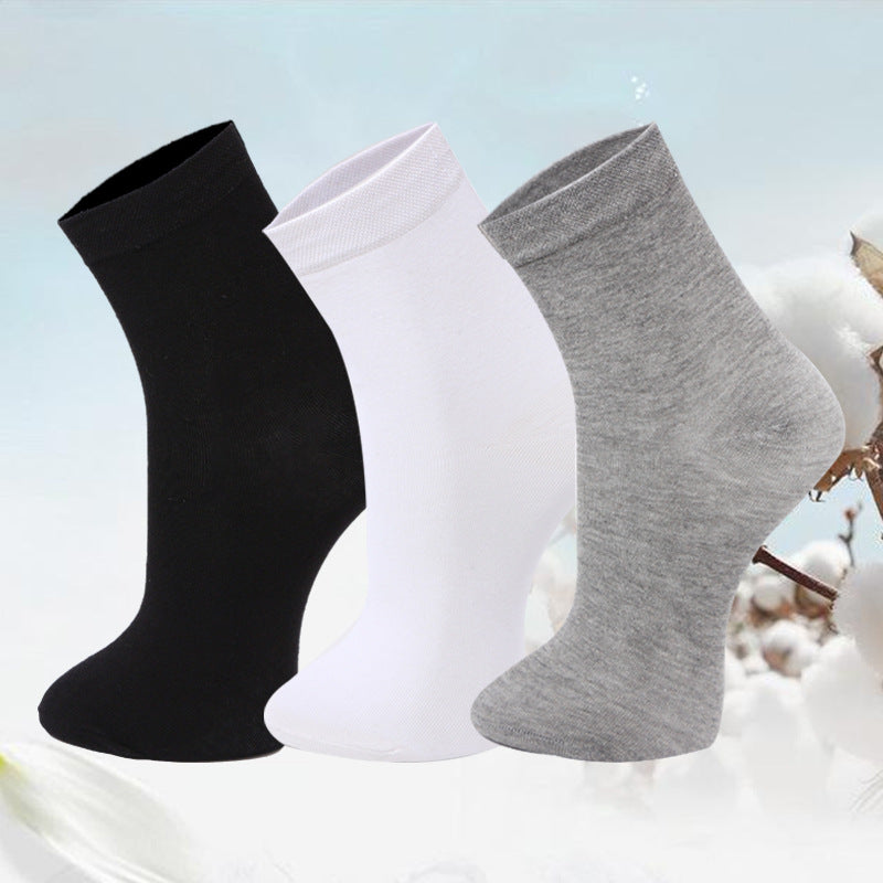 Set of three ankle socks in black, white, and gray against a cotton plant background