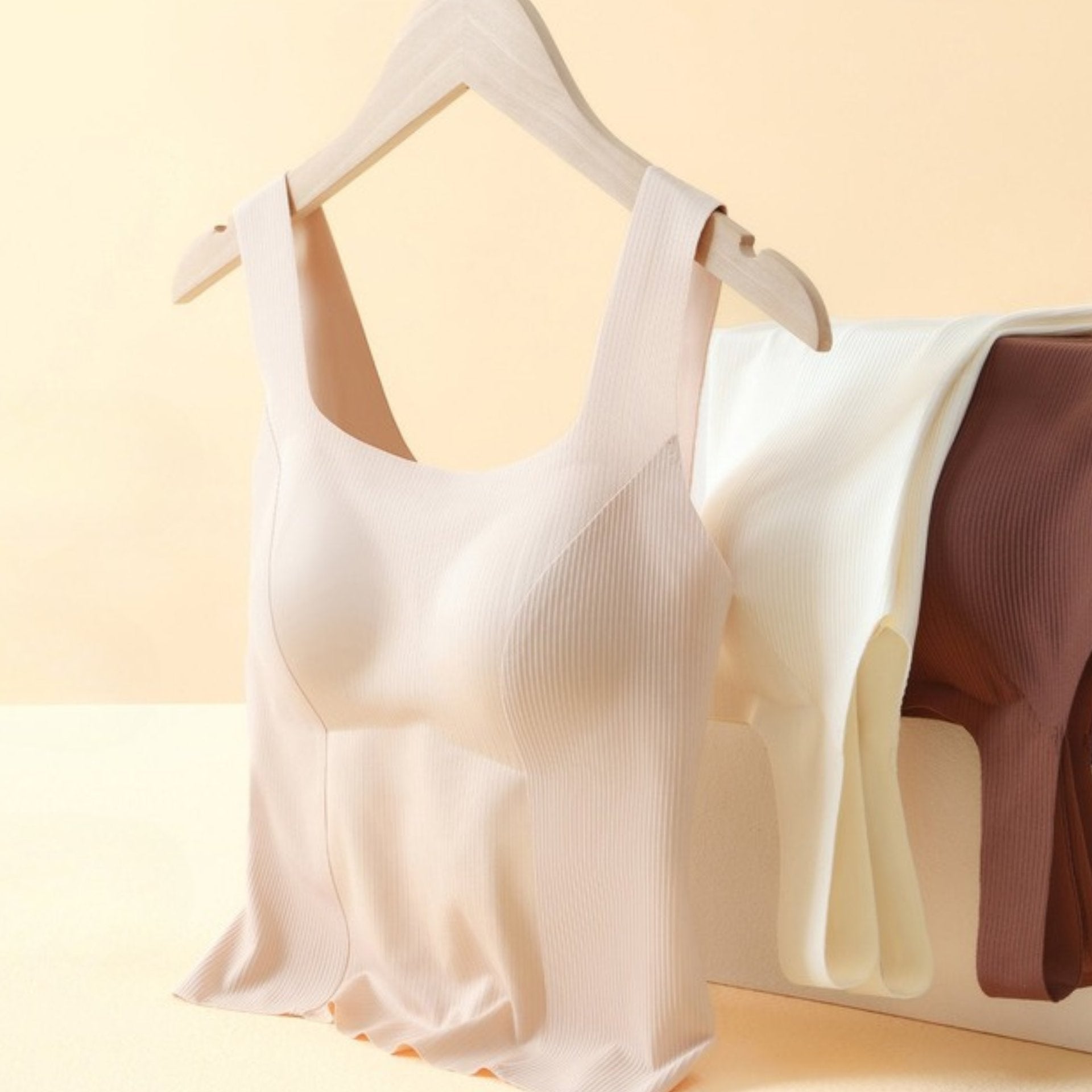 Beige ribbed tank top with built-in bra, displayed on a hanger with multiple color options.
