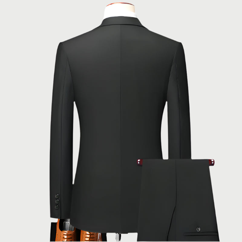 Back view of black suit jacket on mannequin with white collar visible, showing clean tailoring with center vent and sleeve buttons at cuff