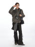 Gray fuzzy fleece jacket on model with black lace-up flared pants and striped accessory, wearing glasses