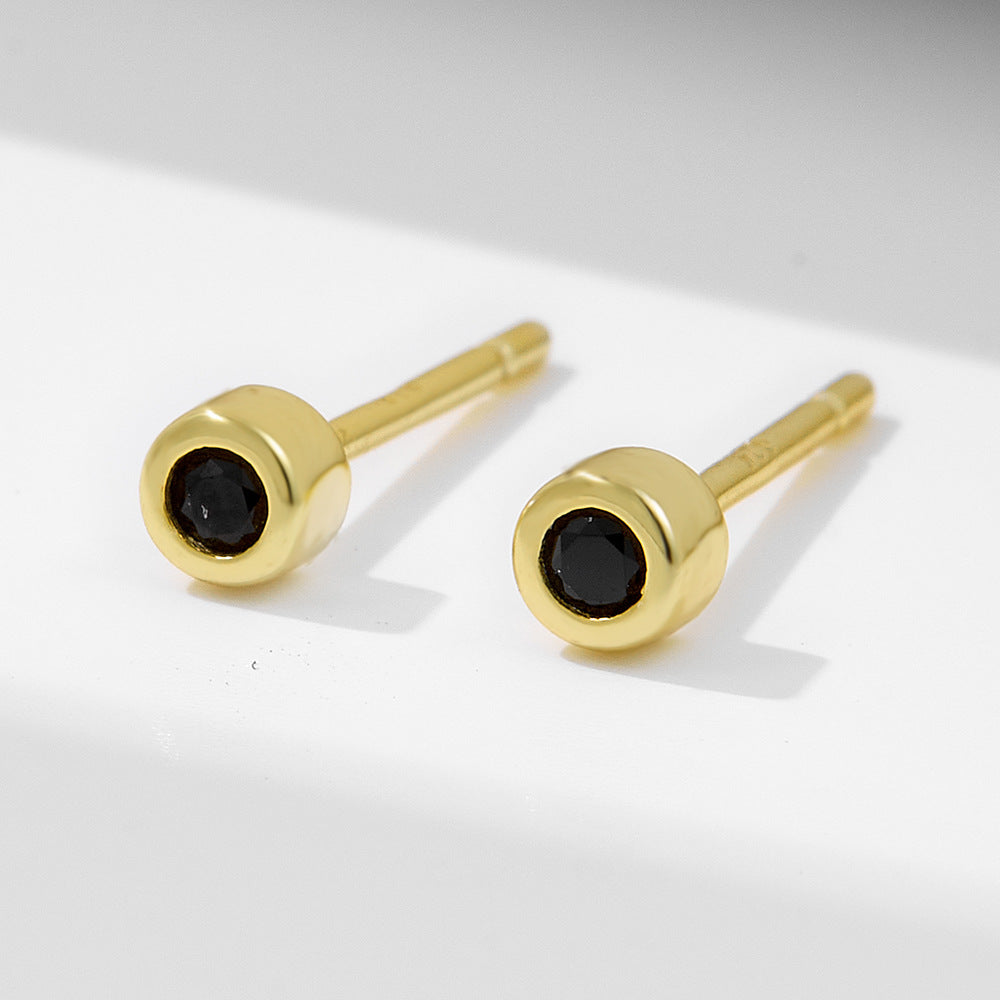 Minimalist gold-plated stud earrings with black nano zirconia stones, front view on white background