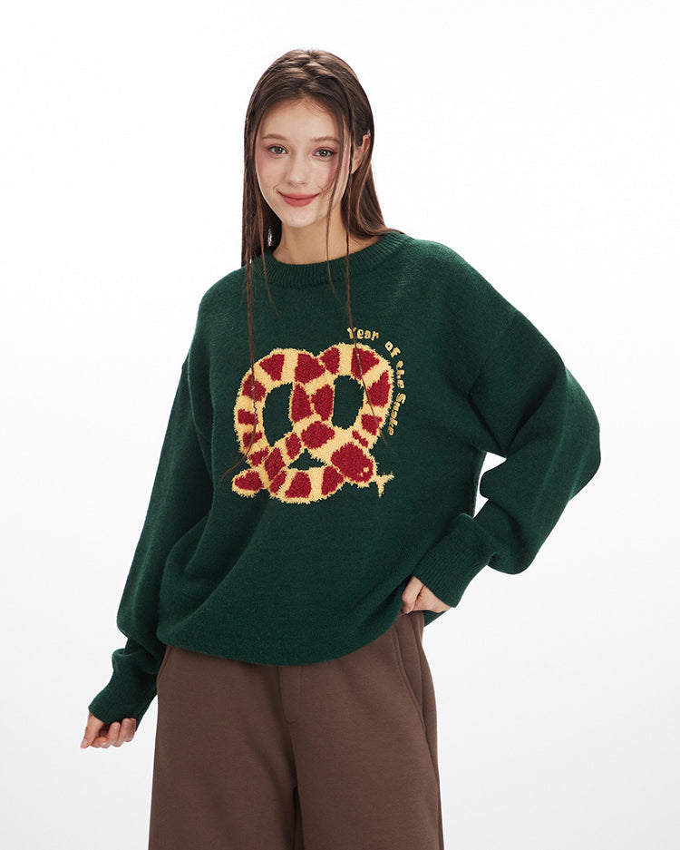 Oversized knit sweater in forest green with embroidered red and gold pretzel design and 'Year of' text