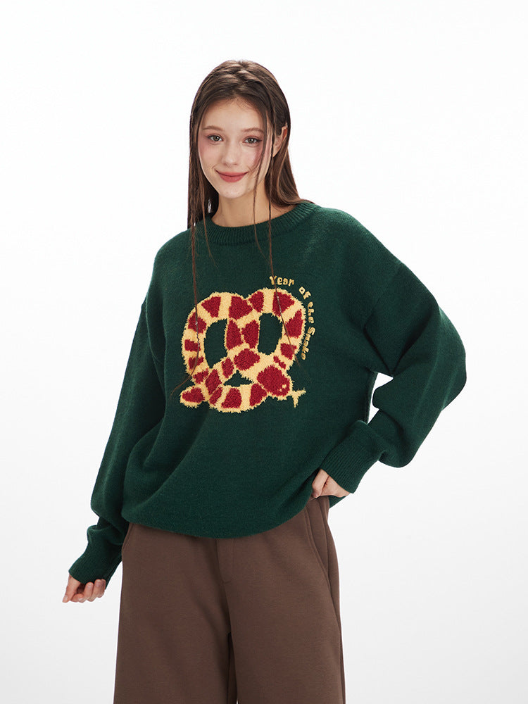 Oversized knit sweater in forest green with embroidered red and gold pretzel design and 'Year of' text