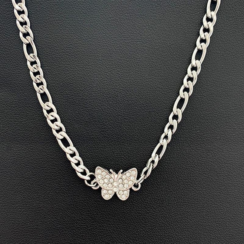 Silver chain necklace with rhinestone butterfly charm displayed on black leather background