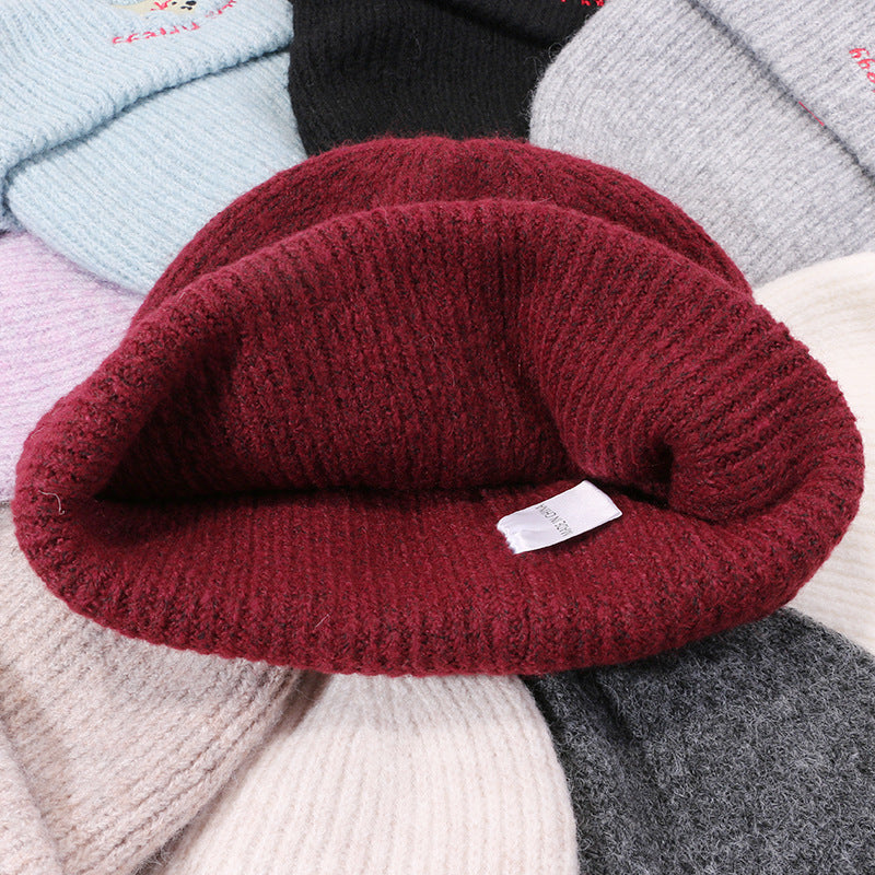 Close-up of burgundy ribbed knit beanie texture showing material detail