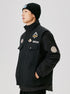 Side view of black military-style jacket with embroidered patches, showing camping logo and special number badge on sleeve