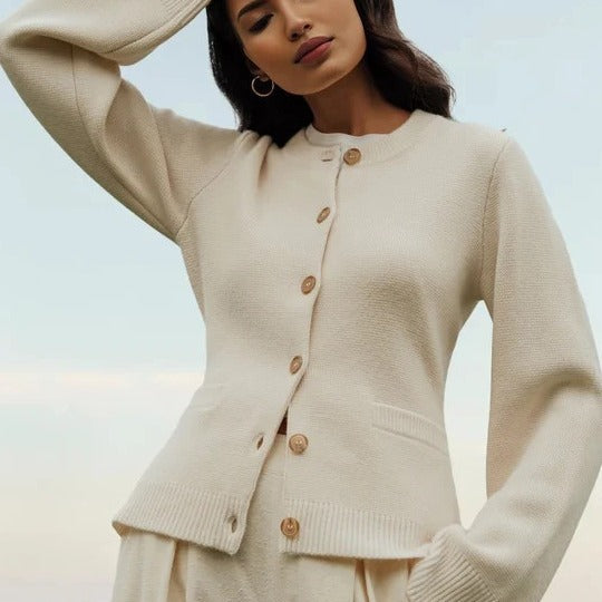 Beige-colored button-up cardigan, model in soft neutral styling with minimalist pose