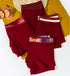 Collection of burgundy men's boxer briefs with various waistband designs displayed on textured golden surface