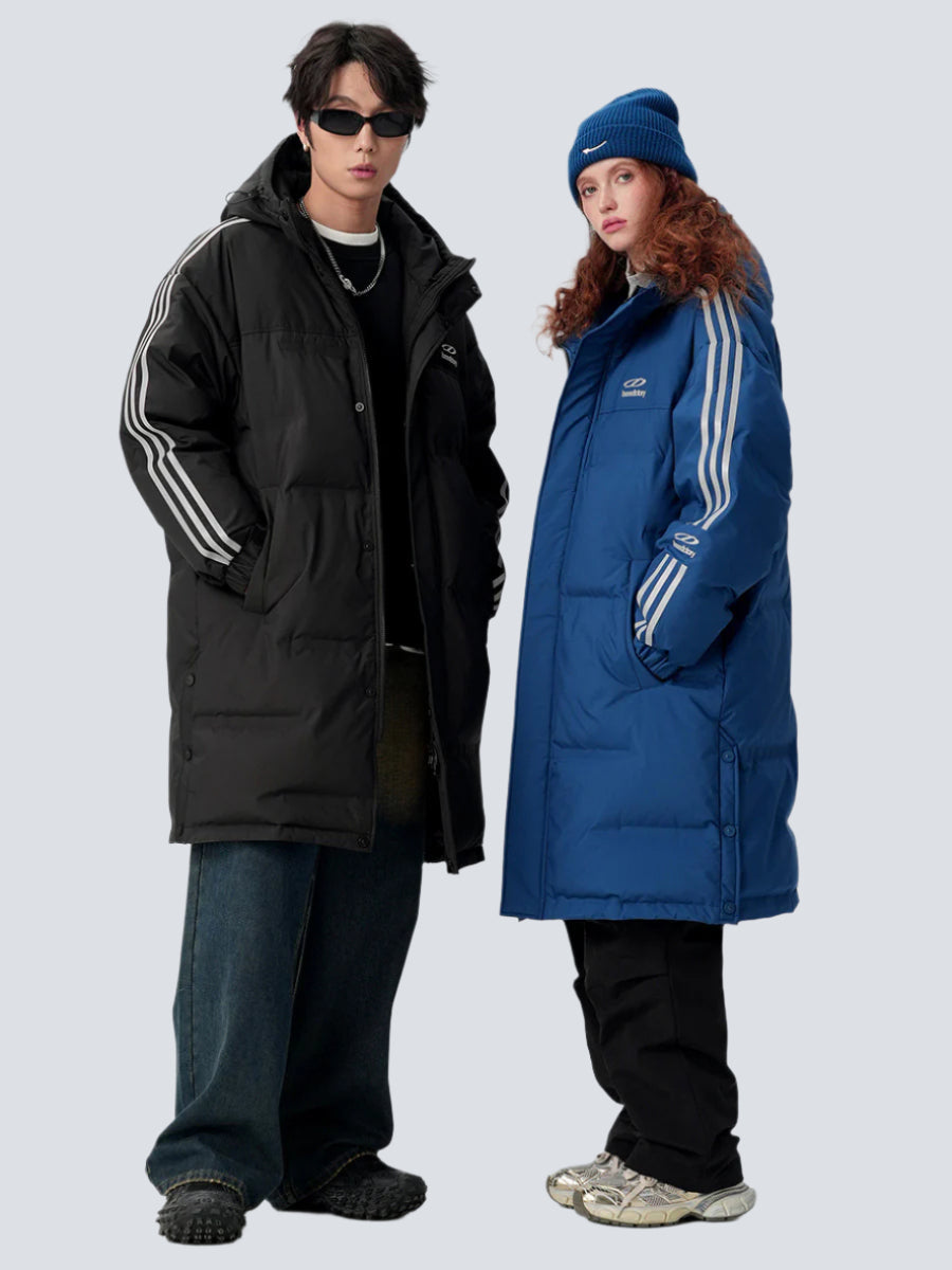 A man and woman are posing side by side against a gray background. Both wearing Benedictory puffer parkas with triple stripe sleeves and oversized fit
