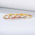 Side view of four gold stackable rings with multicolor, pink, blue and light blue stones showcasing prong settings