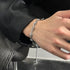 Silver spiked chain bracelet with adjustable length, worn on wrist with a black outfit for an edgy and modern style.