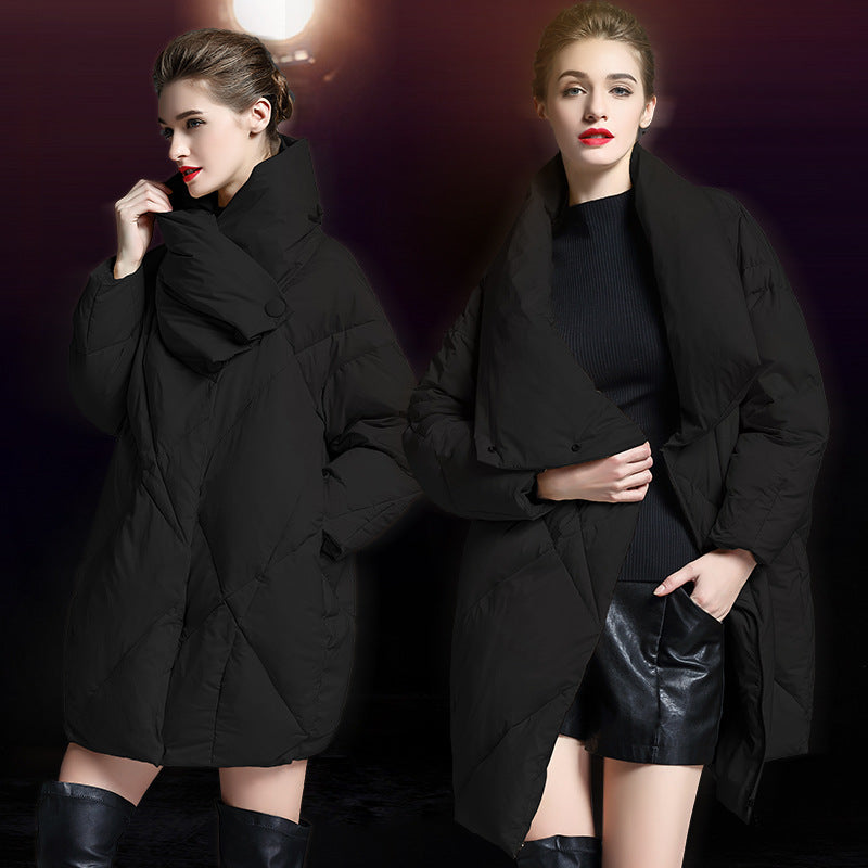 Model in black cocoon puffer coat shown from two angles, styled with black sweater, leather skirt and tall boots