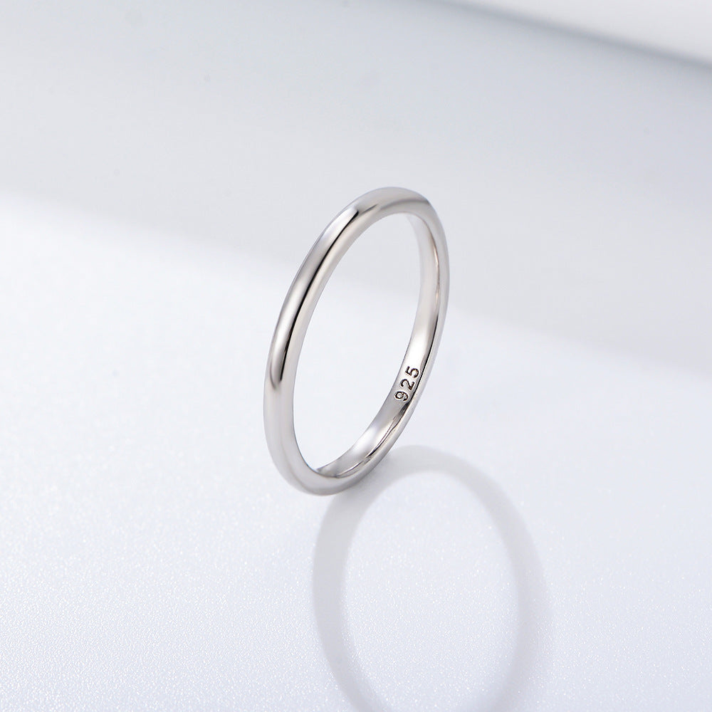 A silver sterling 925 stamped minimalist ring band displayed at angle on white background