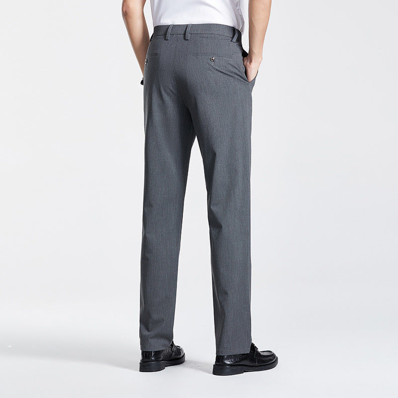Rear view of gray dress pants with buttoned back pockets, displayed on model with white shirt and black shoes