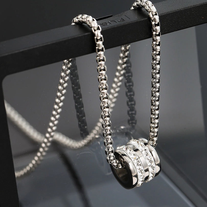 Silver chain necklace with cylindrical pendant featuring crystal bands