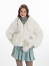 White faux fur jacket over gray turtleneck, accessorized with pearl necklace and matching sage skirt