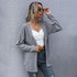 Stylish layered look with grey cardigan, white crop top, and designer belt