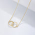 Gold interlocking circles necklace with diamond-encrusted circle and plain circle pendant on delicate chain against angled white surface