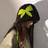 Black fluffy winter hat featuring bright lime green crochet bow and matching green braided cord