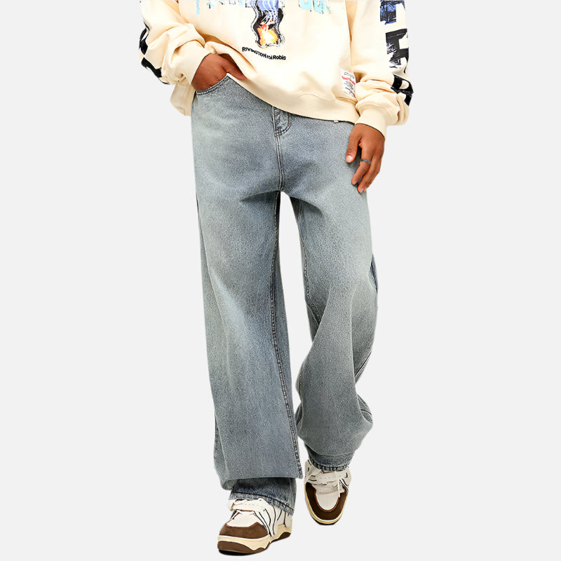 Light wash wide-leg denim jeans paired with cream graphic sweatshirt and retro brown sneakers, showcasing modern streetwear styling