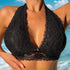 A woman wearing a black lace bralette with plunging neckline, featuring detailed floral lace patterns