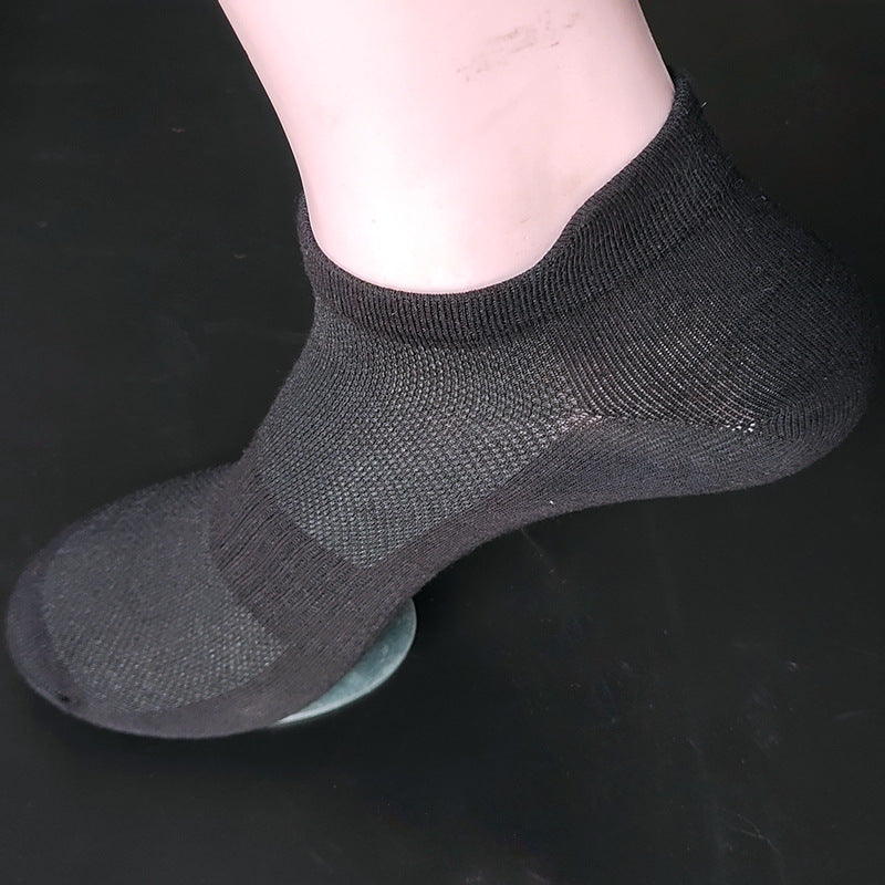 Black ankle sock displayed on mannequin foot showing breathable mesh construction and ribbed elastic cuff against dark background