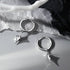 Silver star drop hoop earrings pair on textured white and black marble background