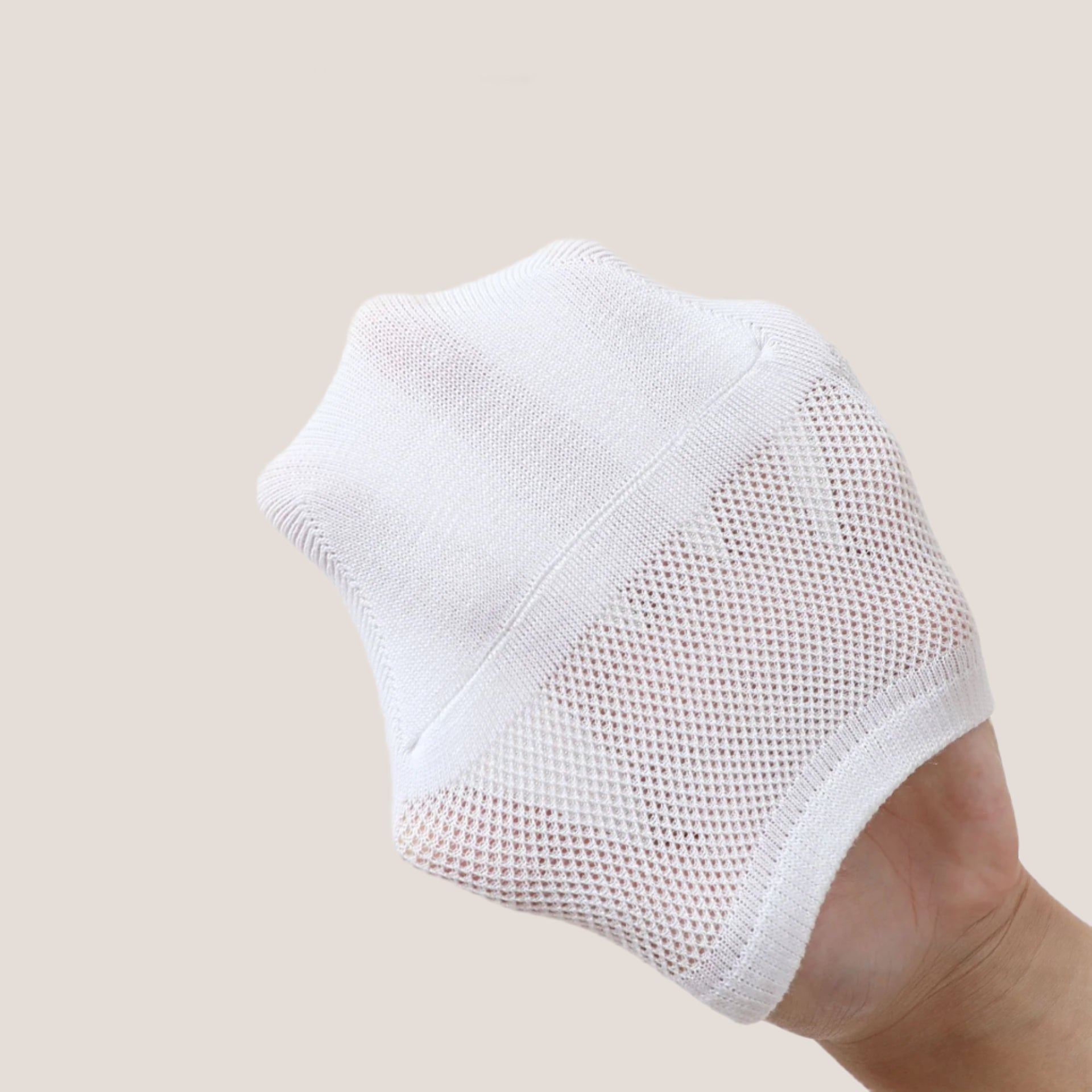 Detailed view of white no-show sock showing mesh ventilation pattern and comfort fit design